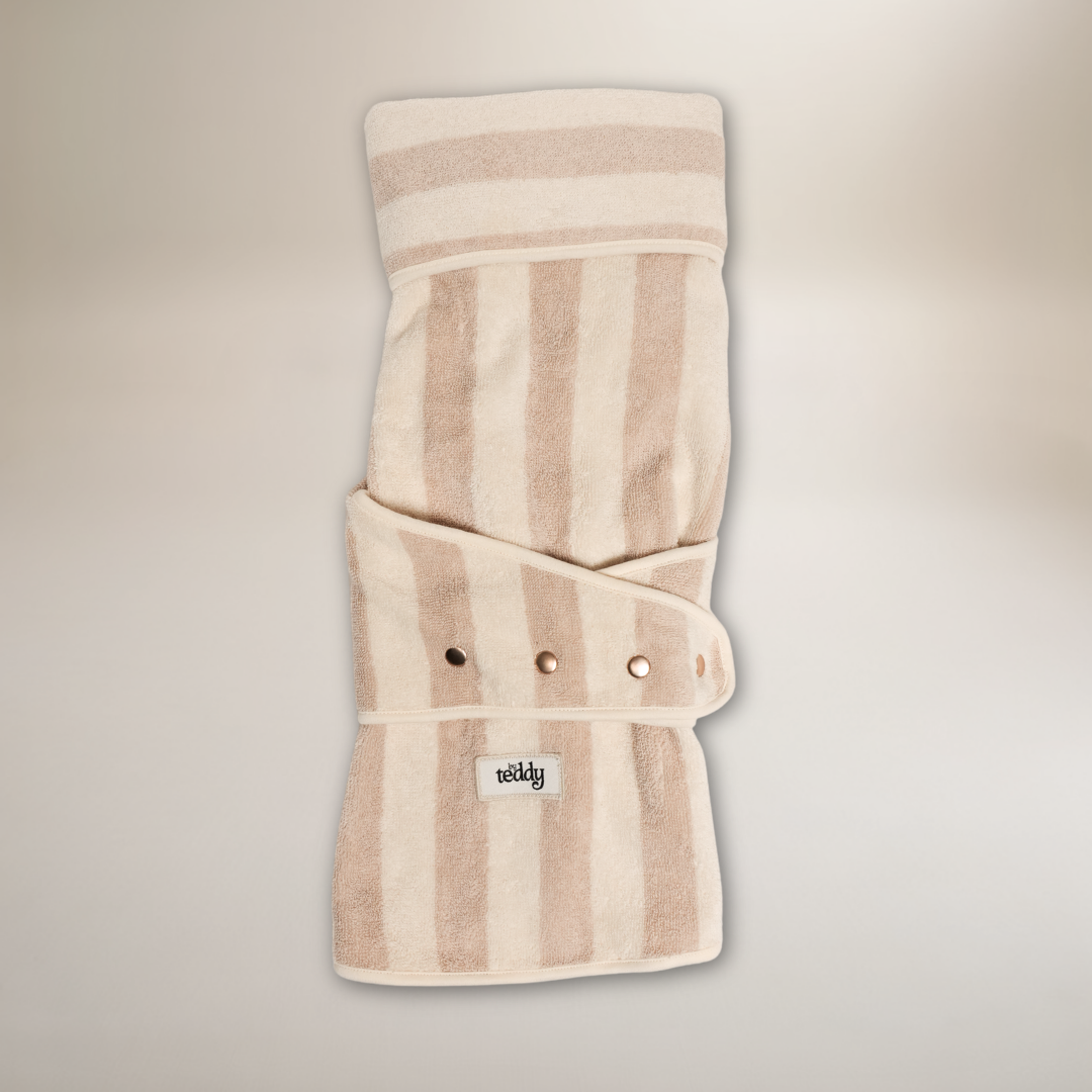 Beige striped baby wrap with a brand label on a light gray background