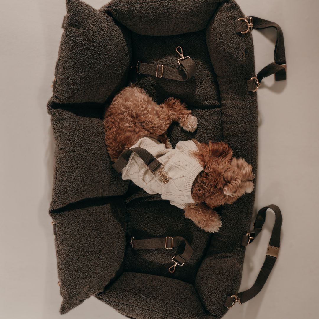 Dark gray backpack with teddy bear and dog plush toys on a light gray background