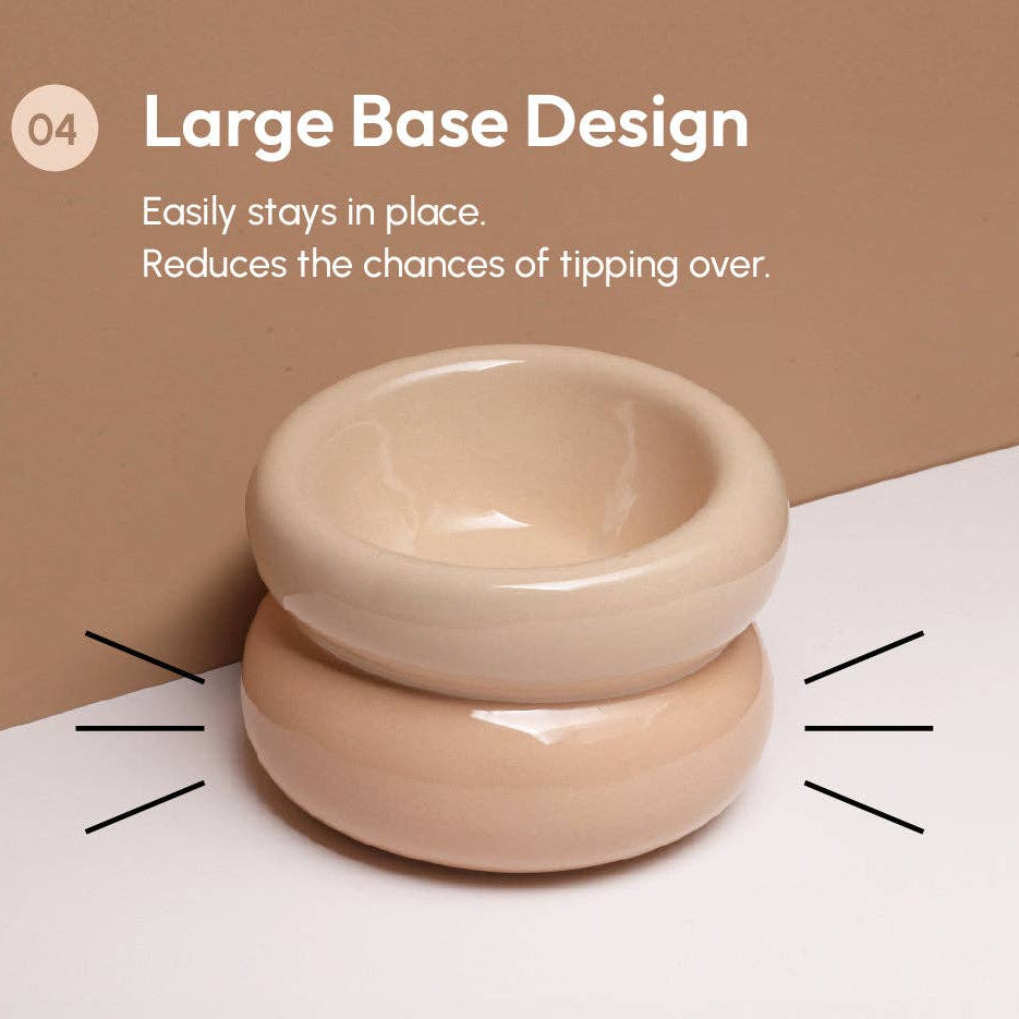 Two beige bowls stacked on a white surface with text about a large base design.