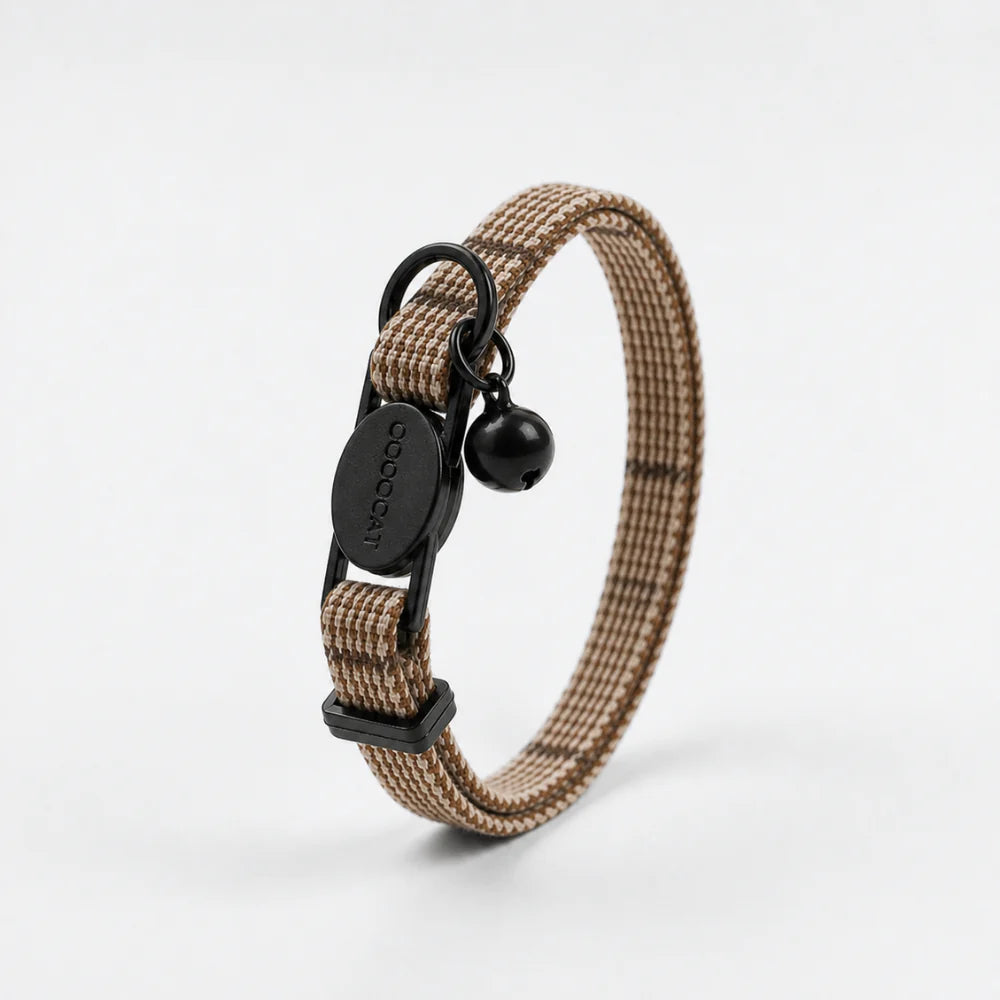 Beige dog collar with black hardware on a white background