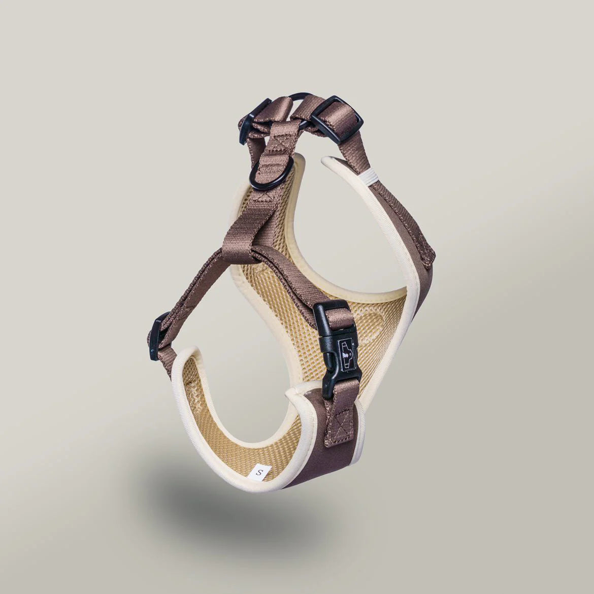 Brown and beige dog harness on a light gray background