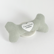 Dog bone-shaped toy with a heart-shaped tag displaying 'Cocopup London' on a white background