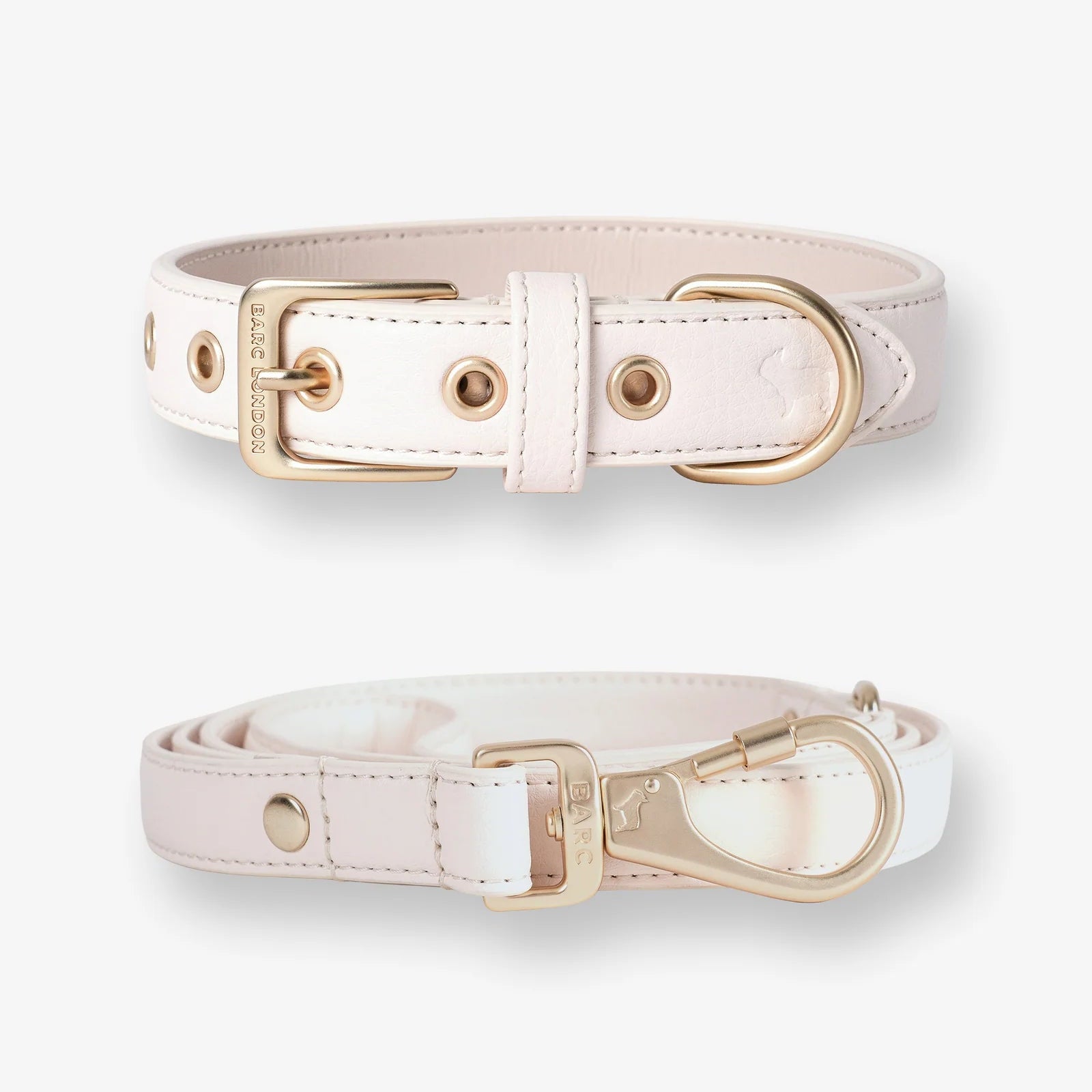 Two white dog collars with gold hardware on a white background