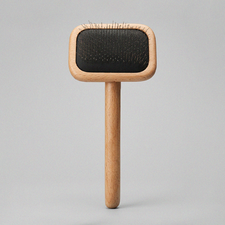 Wooden brush with black bristle head on a gray background