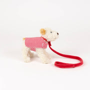 Stuffed animal toy with a red checkered shirt and leash on a white background