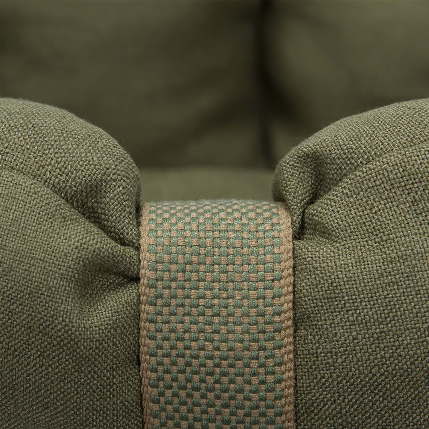 Close-up of green fabric with a woven strap