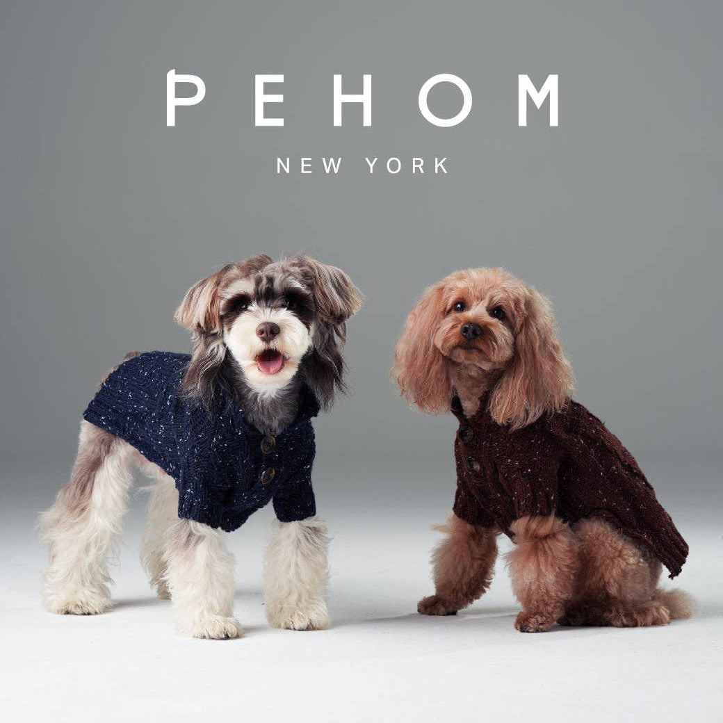 Two dogs wearing sweaters with 'PEHOM New York' text above them on a gray background.