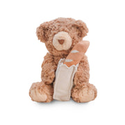 Teddy bear with a bandage on its paw against a white background