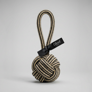 Textured ball with rope and black tag on a light gray background