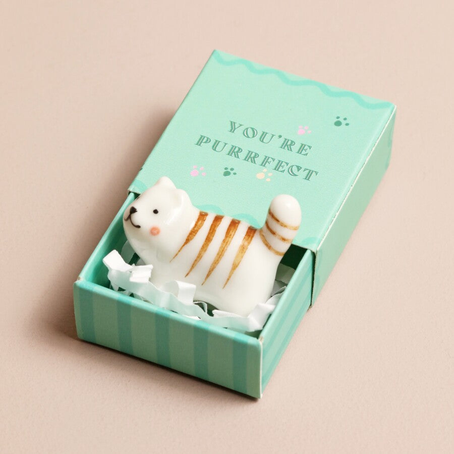 Close-up of the tiny ceramic cat token