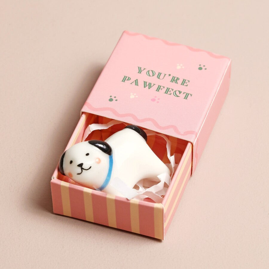 Small dog-shaped candle in a pink box with 'YOU'RE PAWFECT' text on a beige background
