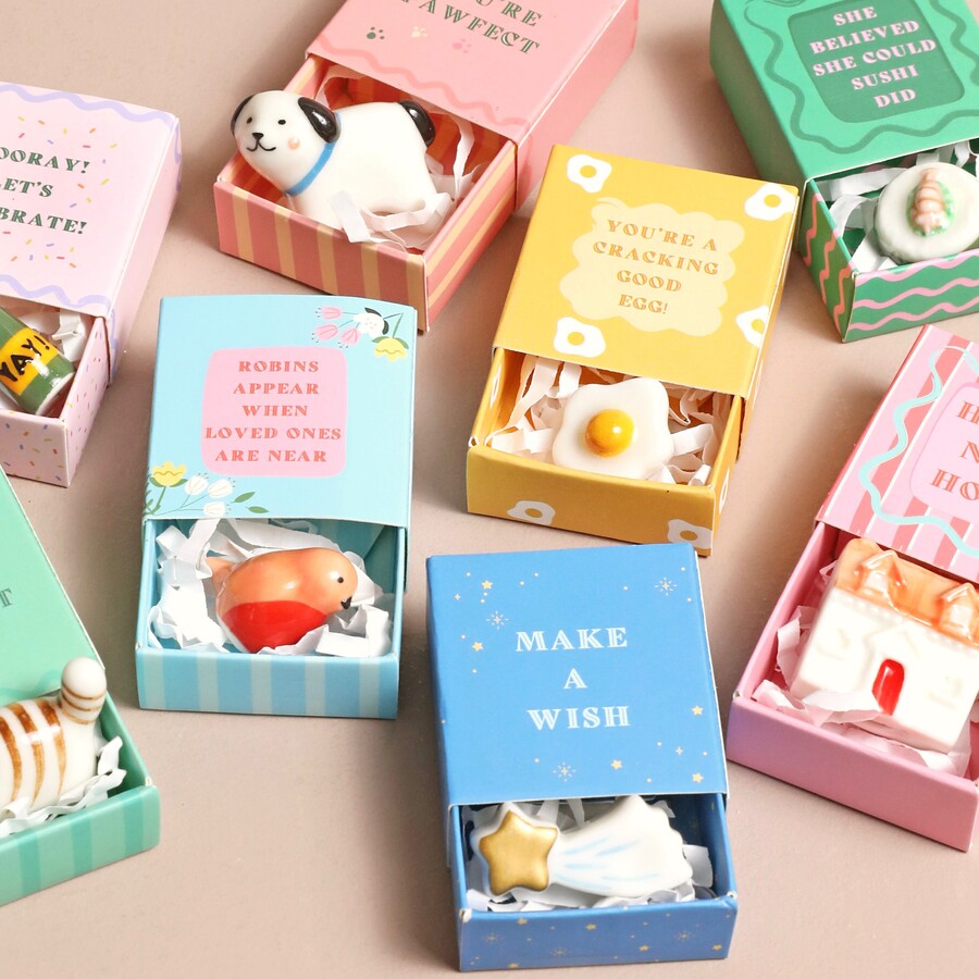 Miniature ceramic objects token inside illustrated matchbox