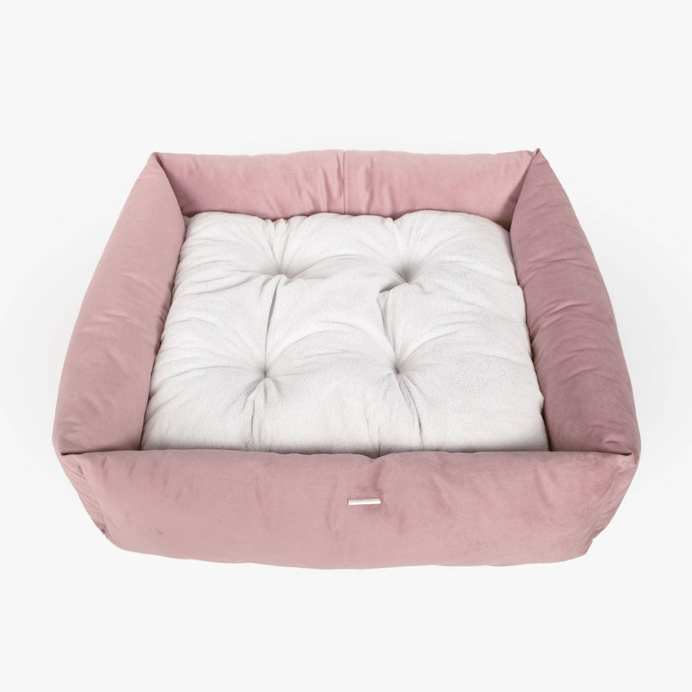 Pink pet bed with a white cushion on a light gray background