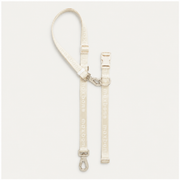 White dog leash with clips on a light gray background