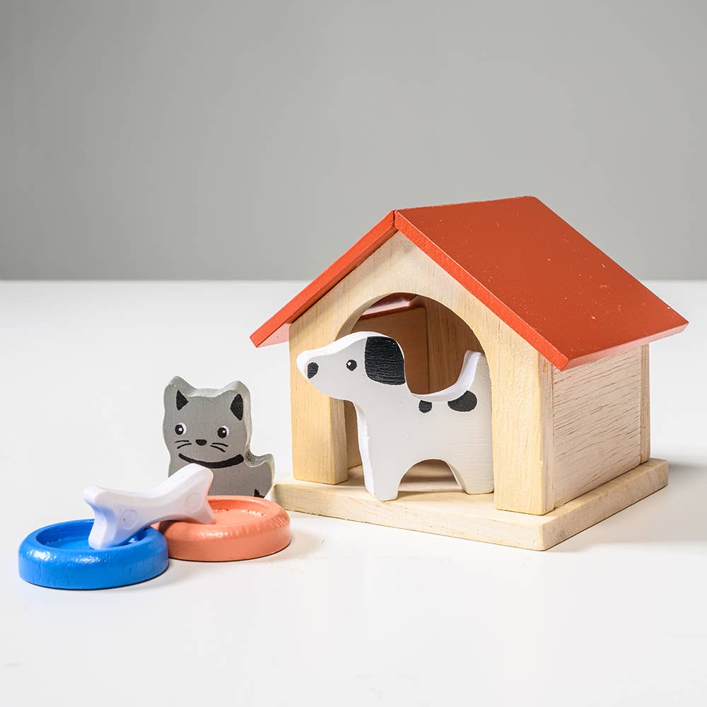 Wooden toy doghouse with a dog and cat figure, and food bowls on a white background
