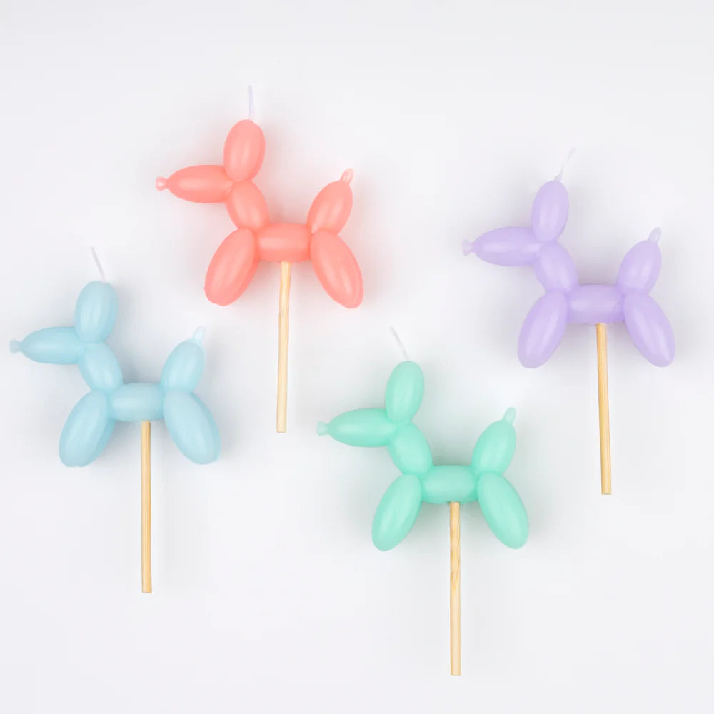 Four balloon animal candles in pastel colors on a white background