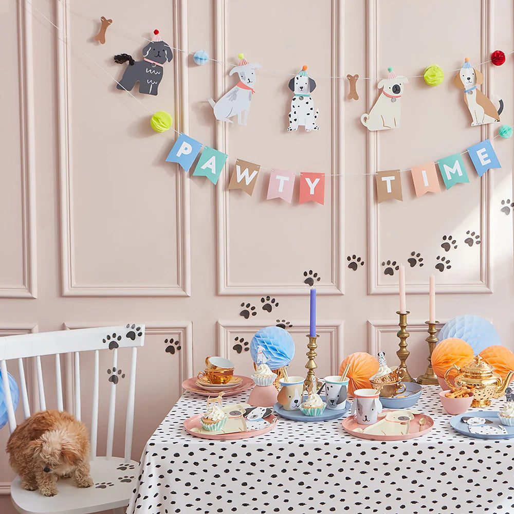 Dining room with paw-themed decorations and a small dog on a chair.