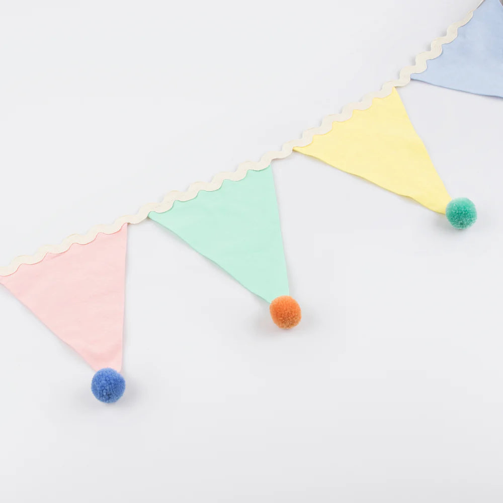 Colorful triangle-shaped bunting with pom-poms on a white background