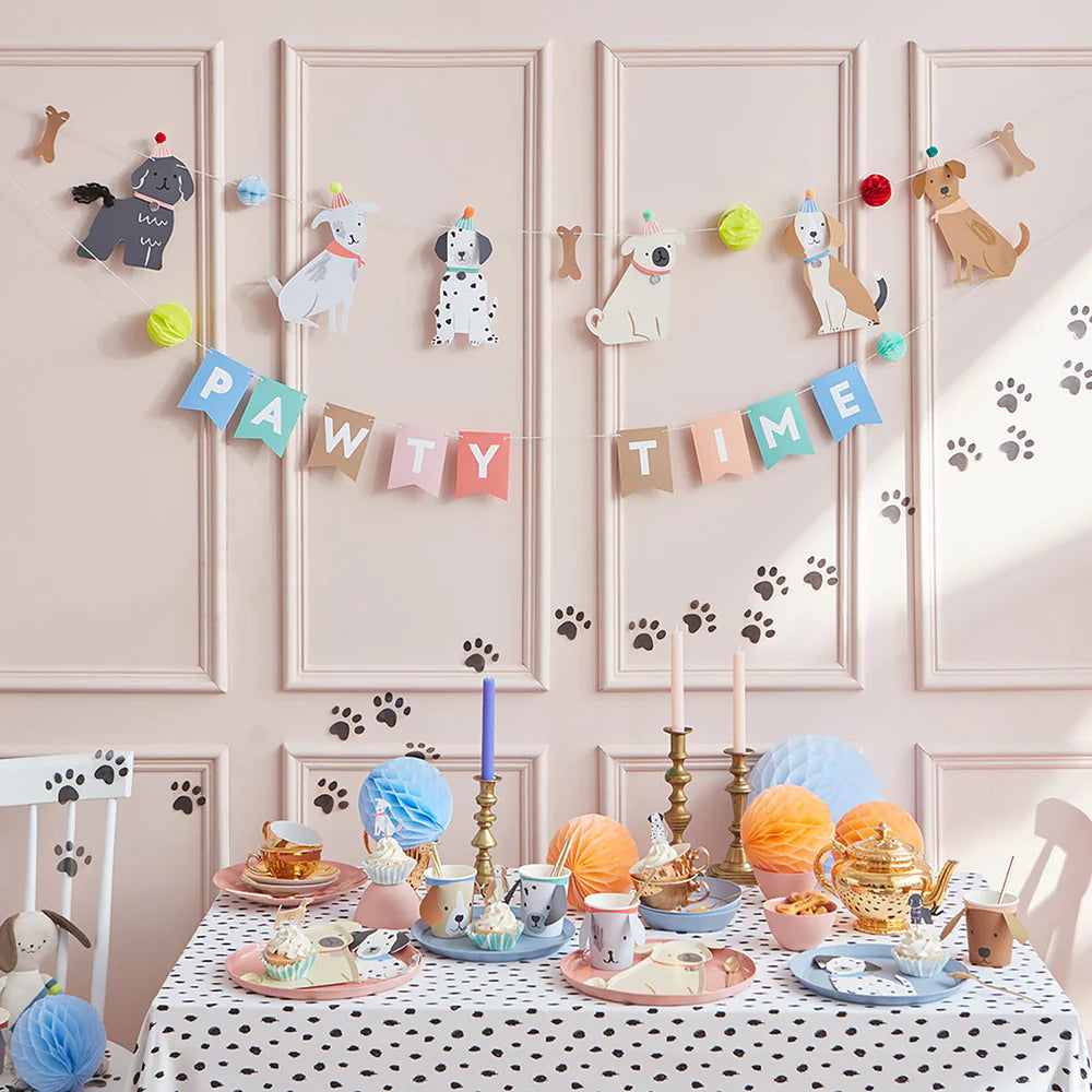 Children's birthday party setup with paw-themed decorations and a table set for a dog-themed celebration.