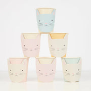 Set of pastel-colored cups with cat faces stacked on a white background