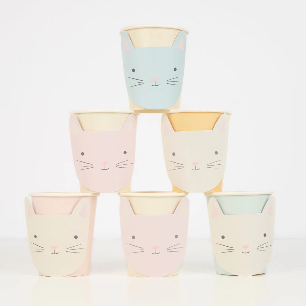 Set of pastel-colored cups with cat faces stacked on a white background