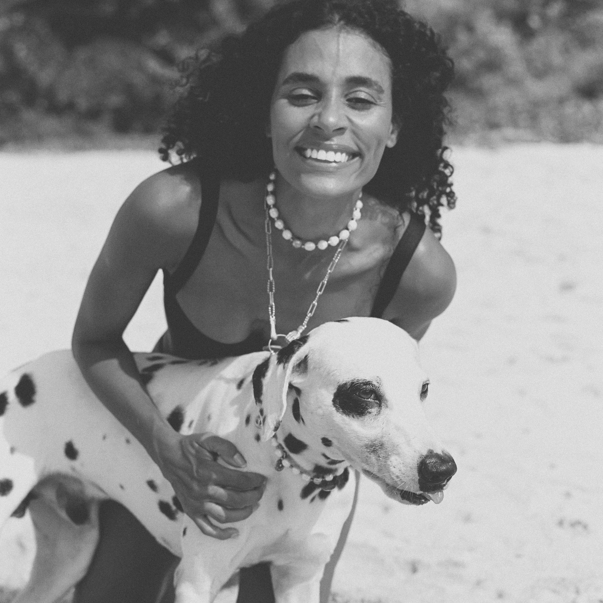 Woman with a Dalmatian dog on a beach