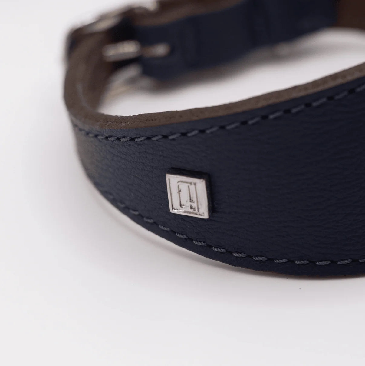 Navy leather belt with a brand logo on a white background