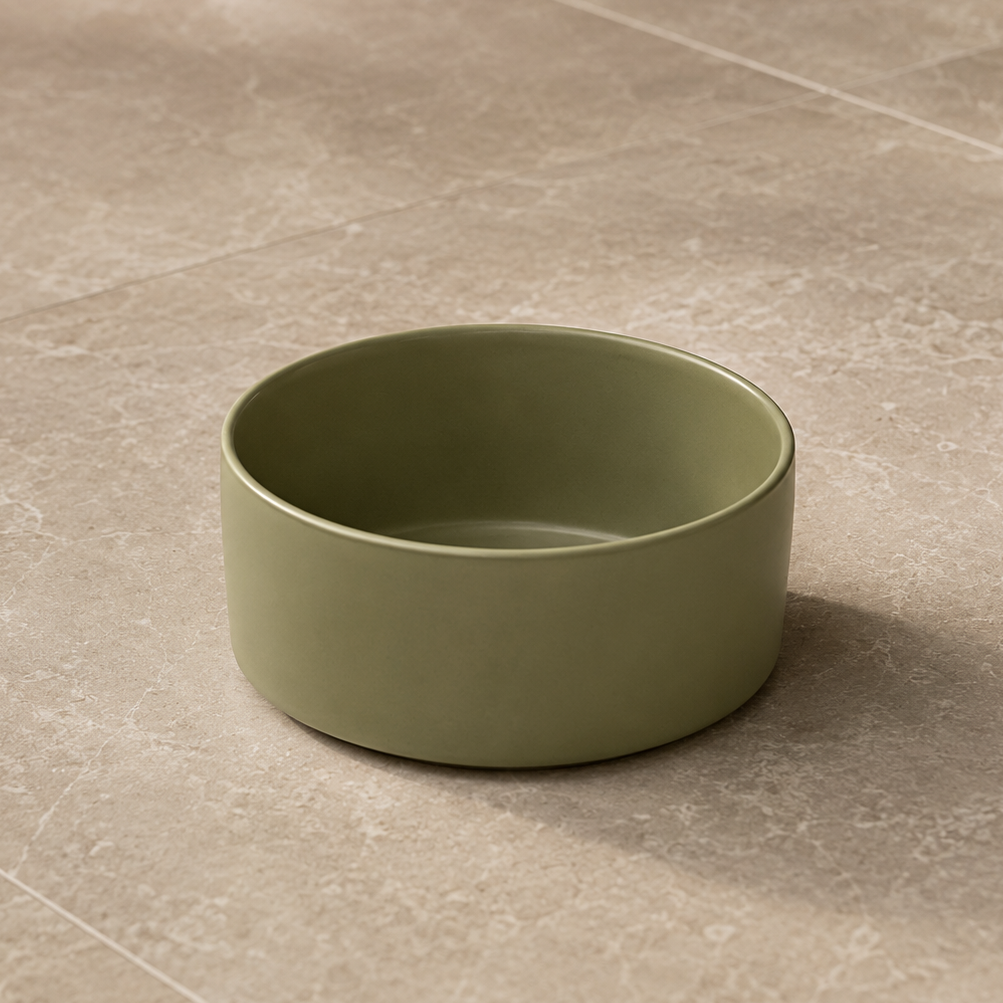 Green ceramic bowl on a beige tiled floor