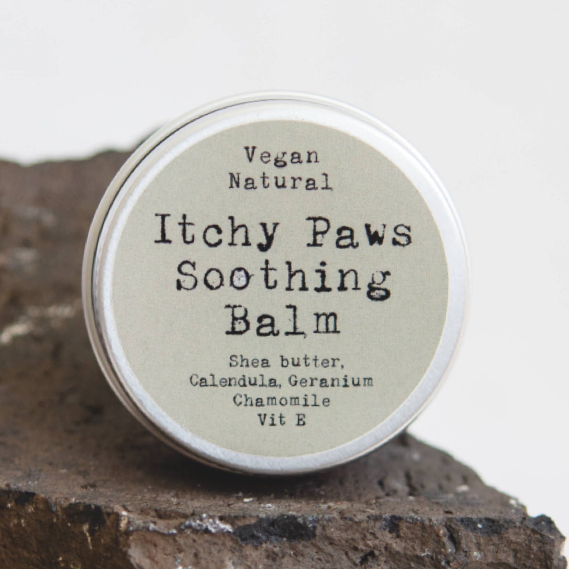 Itchy Paws Soothing Balm container on a wooden surface with a white background