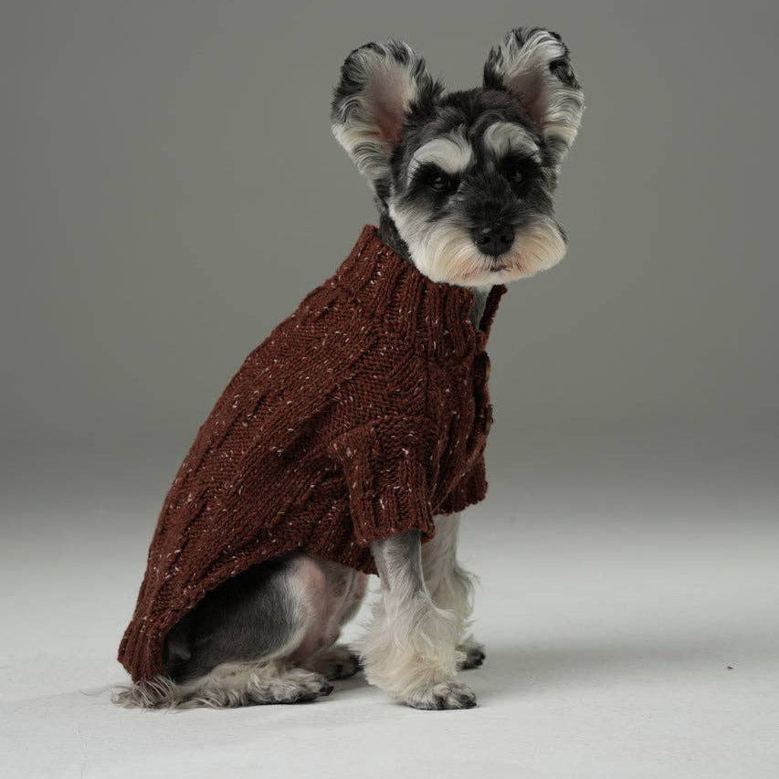 Stuffed dog toy resembling a miniature schnauzer wearing a brown sweater on a gray background