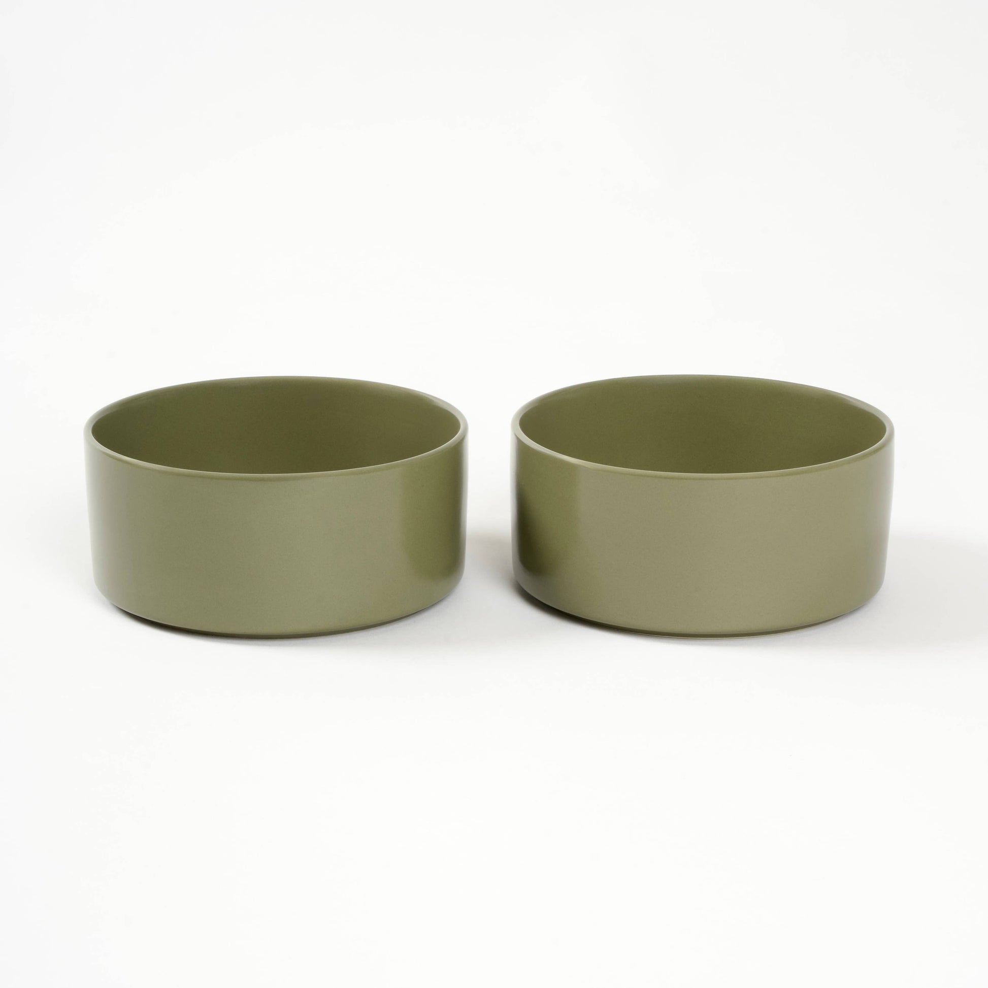 Two green ceramic bowls on a white background