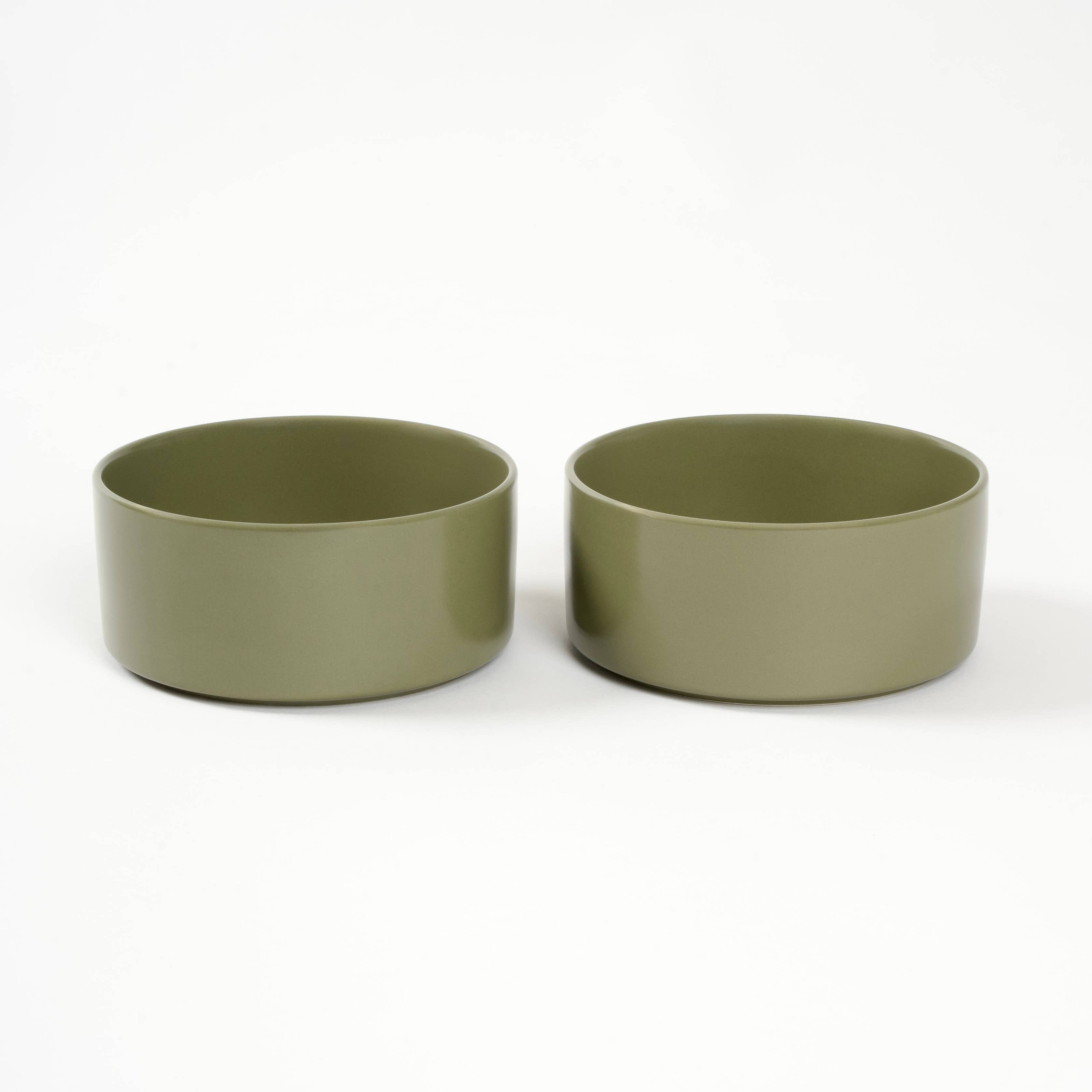 Two green ceramic bowls on a white background