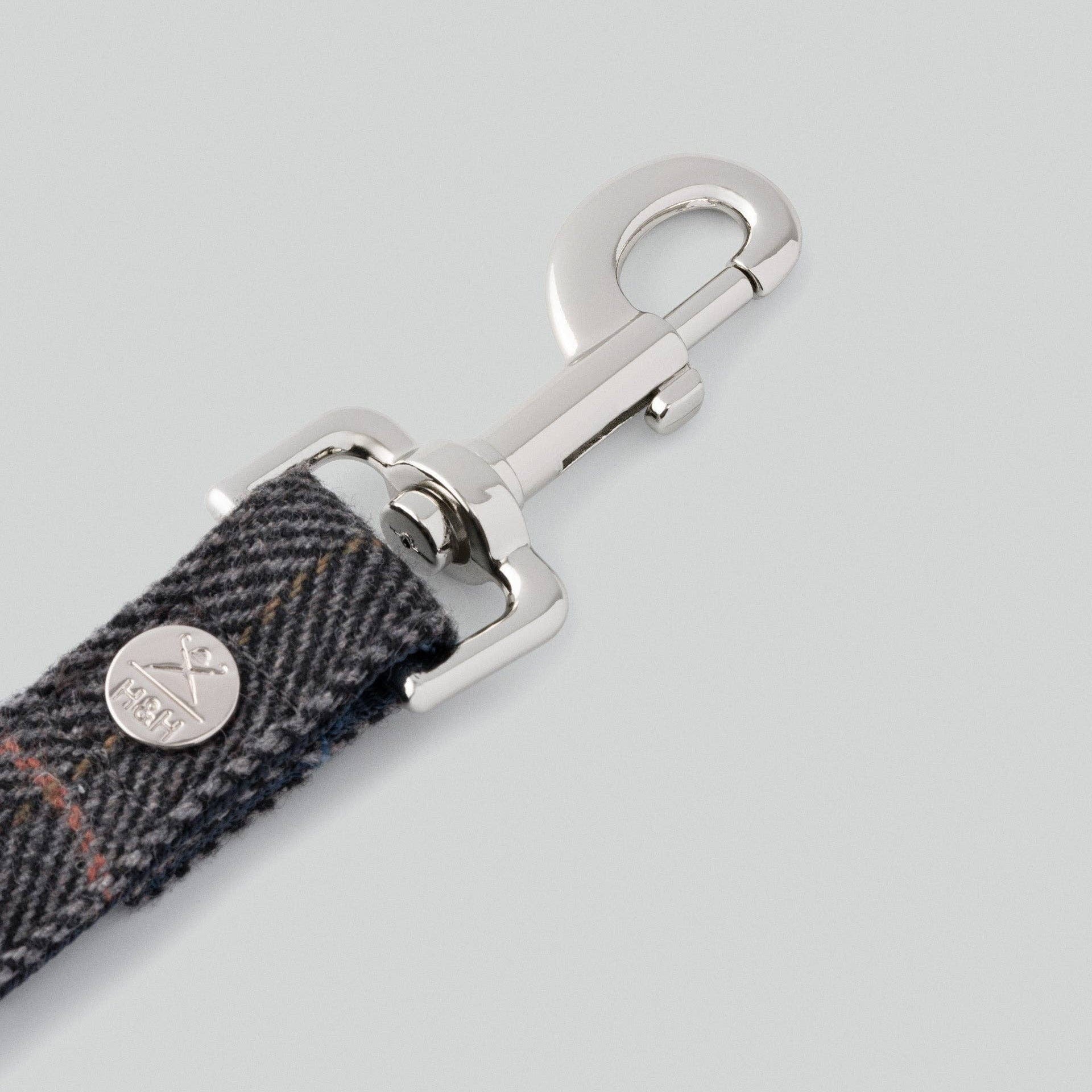 Dog leash with metal clip on a light gray background